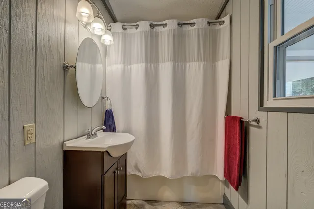 a bathroom with a granite countertop sink toilet and vanity
