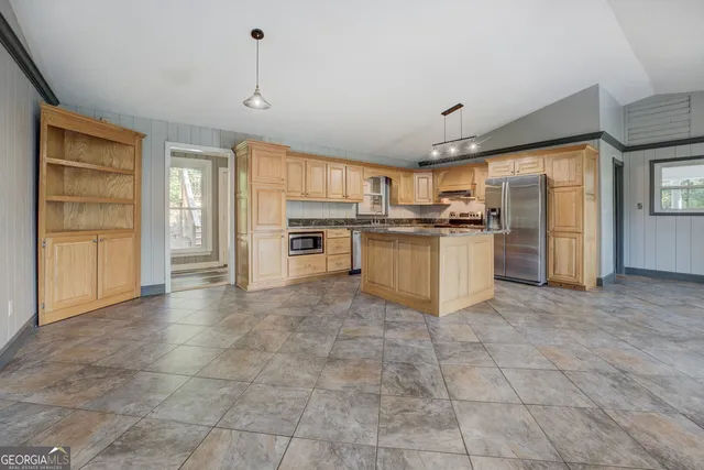 a kitchen with stainless steel appliances granite countertop a stove top oven a refrigerator a sink and dishwasher