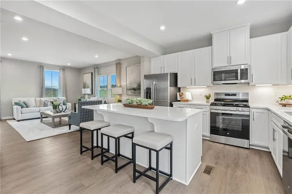 a kitchen with white cabinets and sink