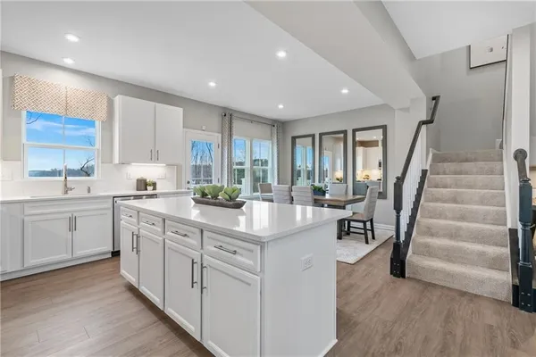 a kitchen with kitchen island a refrigerator stove microwave and cabinets