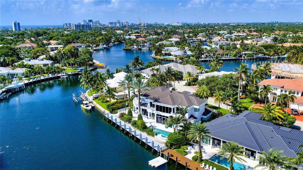 an aerial view of residential houses with outdoor space and lake view