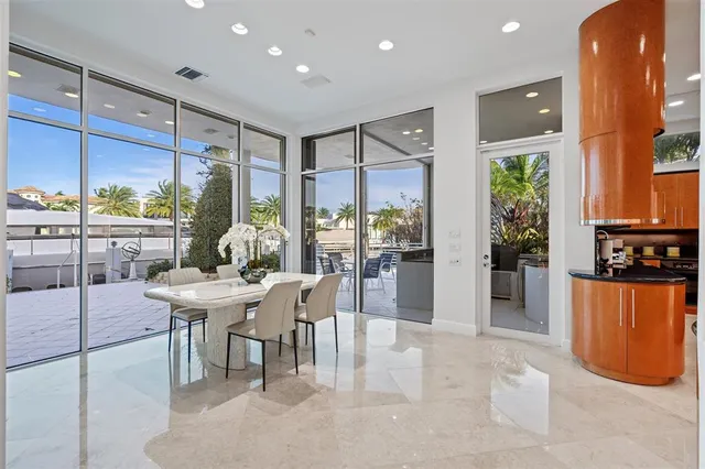 a dining room with stainless steel appliances furniture a window and a kitchen view