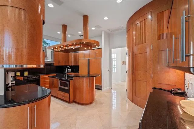 a kitchen with stainless steel appliances granite countertop a sink a stove and a refrigerator