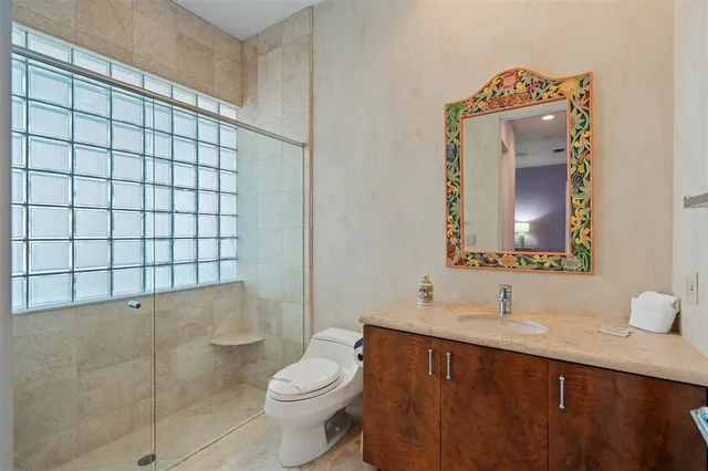 a bathroom with a sink vanity mirror and toilet