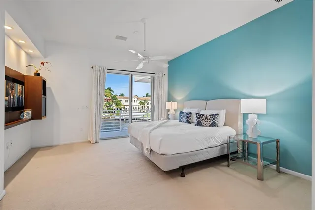 a spacious bedroom with a bed mirror and window