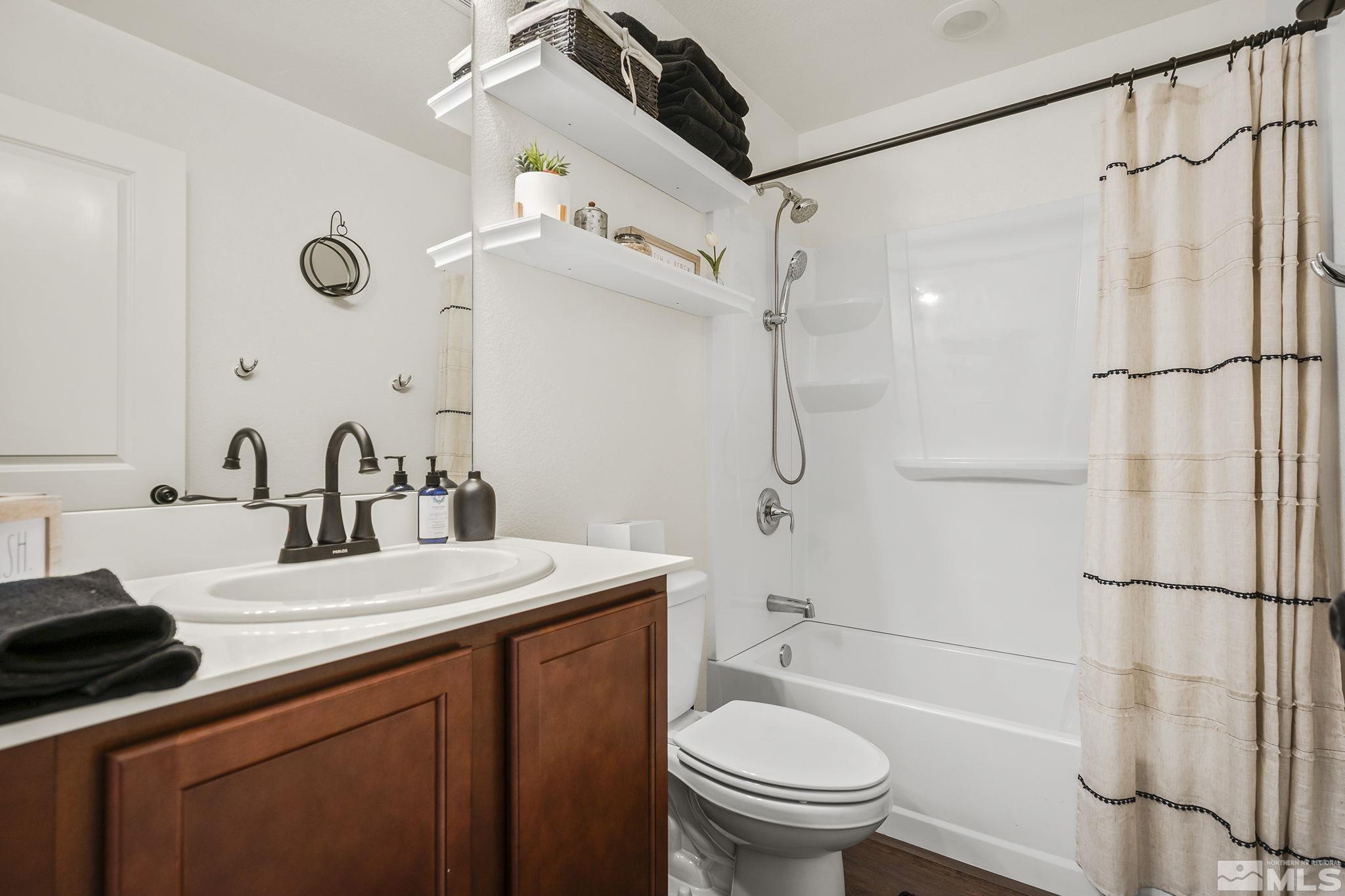 9166 Gulf Court Reno, NV 89506 - Photo 19 of 33 a bathroom with a granite countertop sink toilet and shower