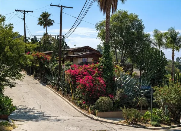 a view of a house with a yard and potted plants
