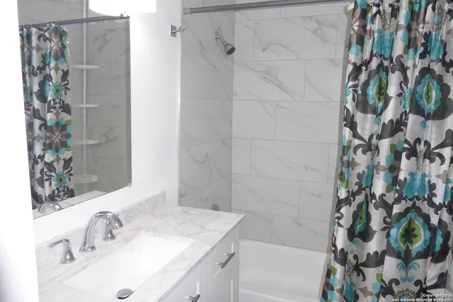 a bathroom with a granite countertop sink a shower and a mirror