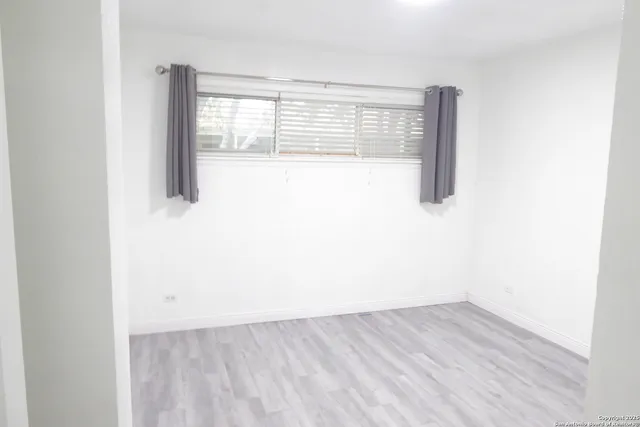 a view of a small space with wooden floor and a window