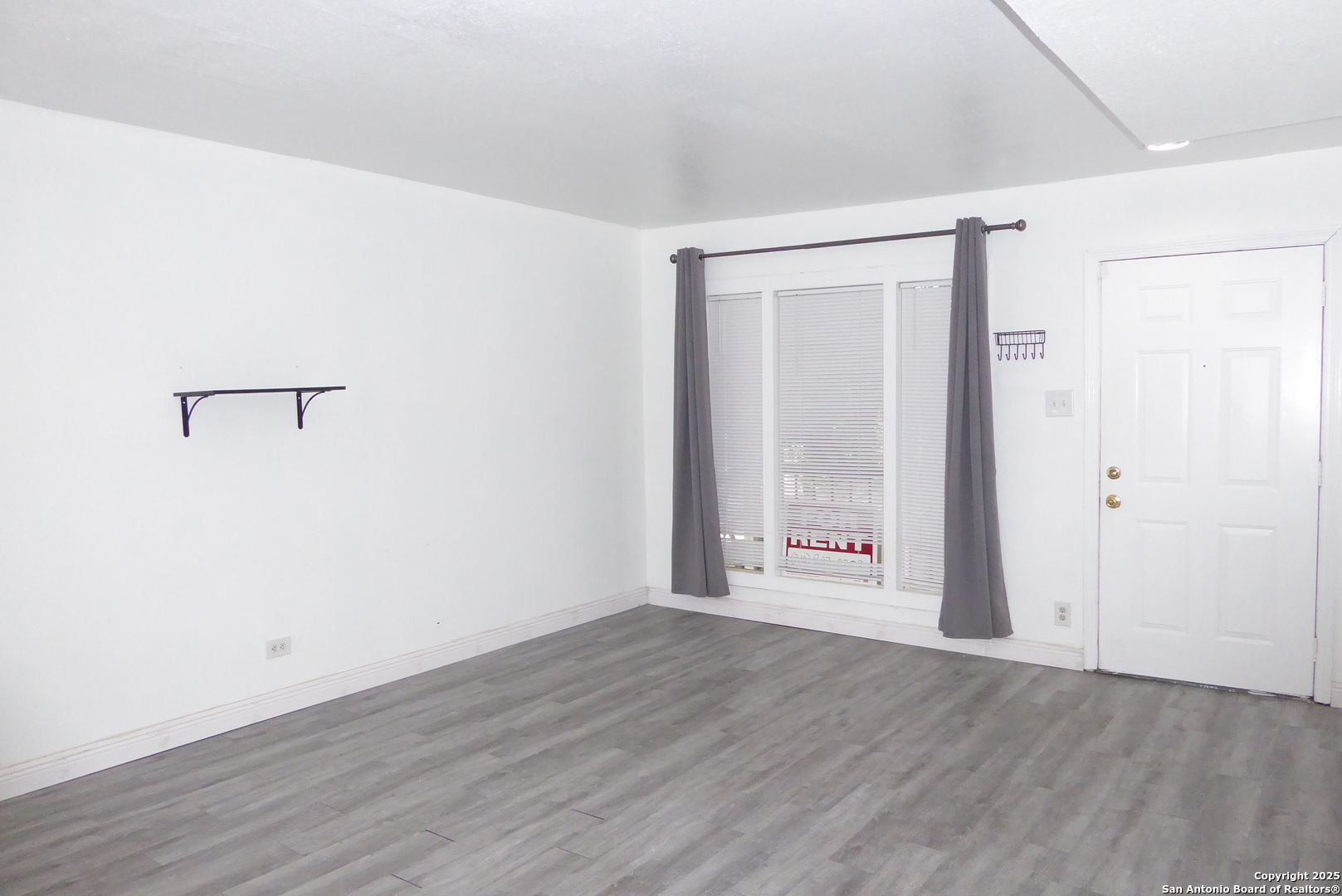 255 East Rampart Drive, Unit 211 San Antonio, TX 78216 - Photo 5 of 17 an empty room with wooden floor and windows