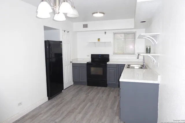 a kitchen with cabinets a sink stainless steel appliances and a window