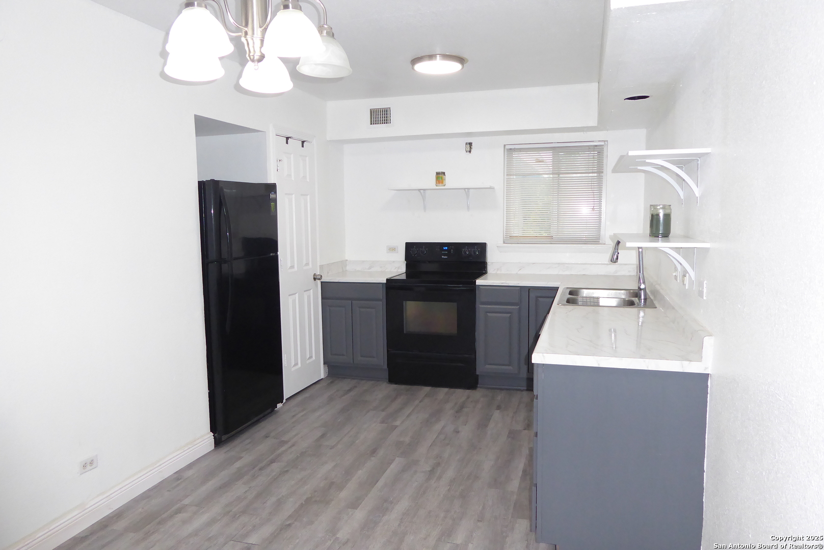 255 East Rampart Drive, Unit 211 San Antonio, TX 78216 - Photo 7 of 17 a kitchen with cabinets a sink stainless steel appliances and a window