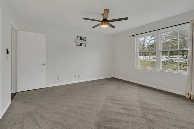 a view of a livingroom with a ceiling fan and window