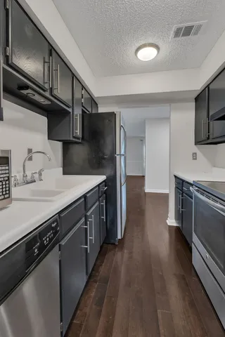 a kitchen with stainless steel appliances a sink dishwasher a stove and cabinets