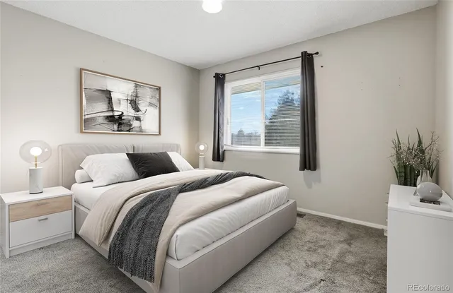 a bedroom with a large bed and a potted plant