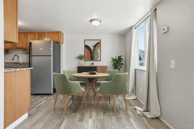 a dining room with furniture a rug a potted plant and wooden floor