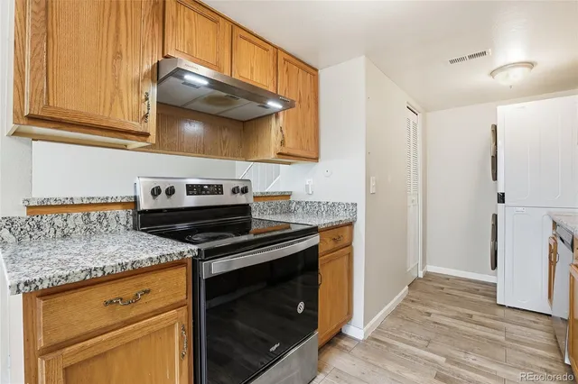 a kitchen with stainless steel appliances granite countertop a stove microwave and cabinets
