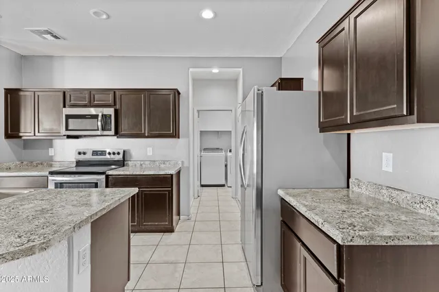 a kitchen with stainless steel appliances granite countertop a refrigerator stove microwave and sink