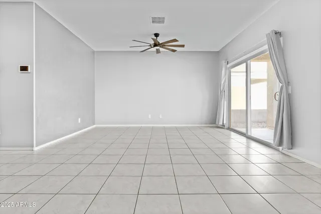 a view of an empty room and window chandelier fan