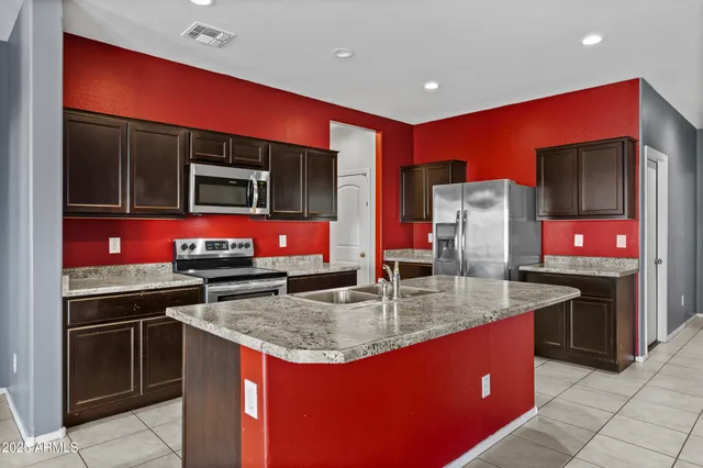 a kitchen with stainless steel appliances granite countertop a stove sink and refrigerator