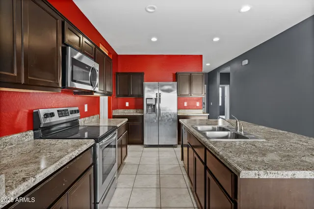 a kitchen with stainless steel appliances granite countertop a sink stove and refrigerator