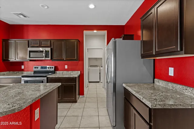 a kitchen with stainless steel appliances granite countertop a stove refrigerator and microwave