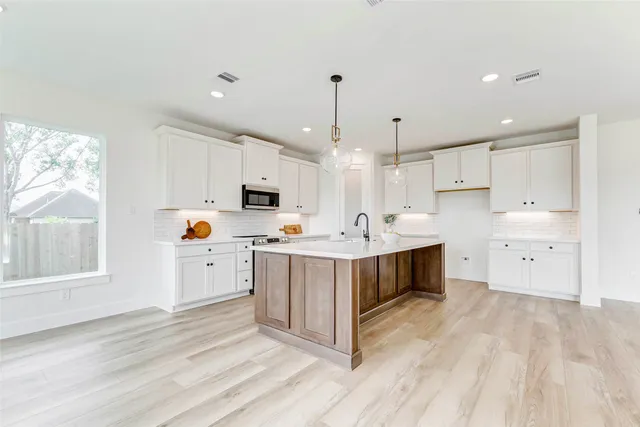 a kitchen with kitchen island white cabinets stainless steel appliances and sink