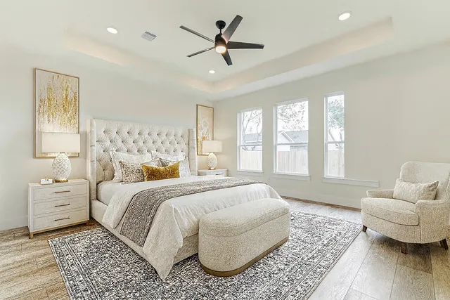 a spacious bedroom with a bed and wooden floor