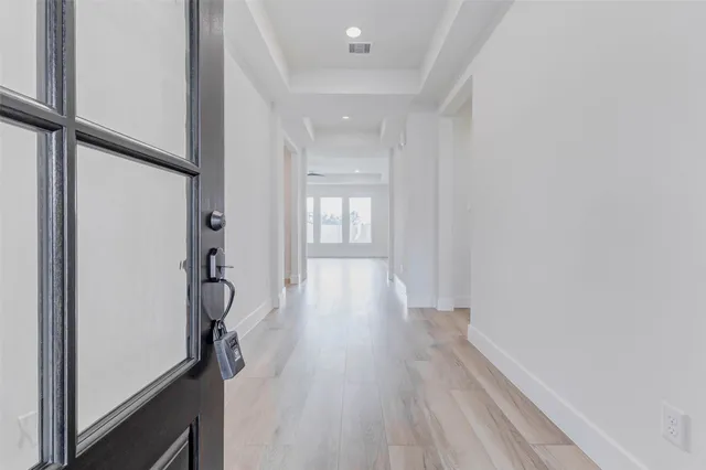 a view of a hallway with wooden floor and staircase