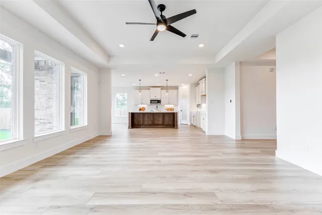 a view of empty room with wooden floor and window