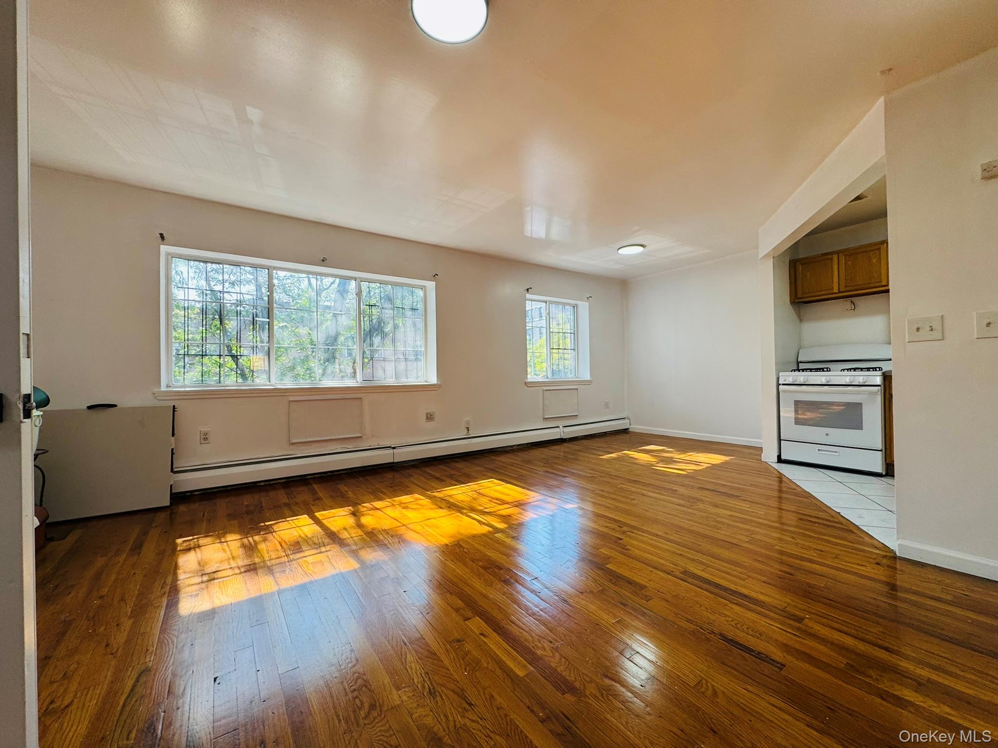 53 West 192nd Street, Unit 3A Bronx, NY 10468 - Photo 2 of 14 a view of a kitchen with wooden floor and electronic appliances
