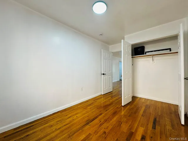 a view of a room with wooden floor and a hallway