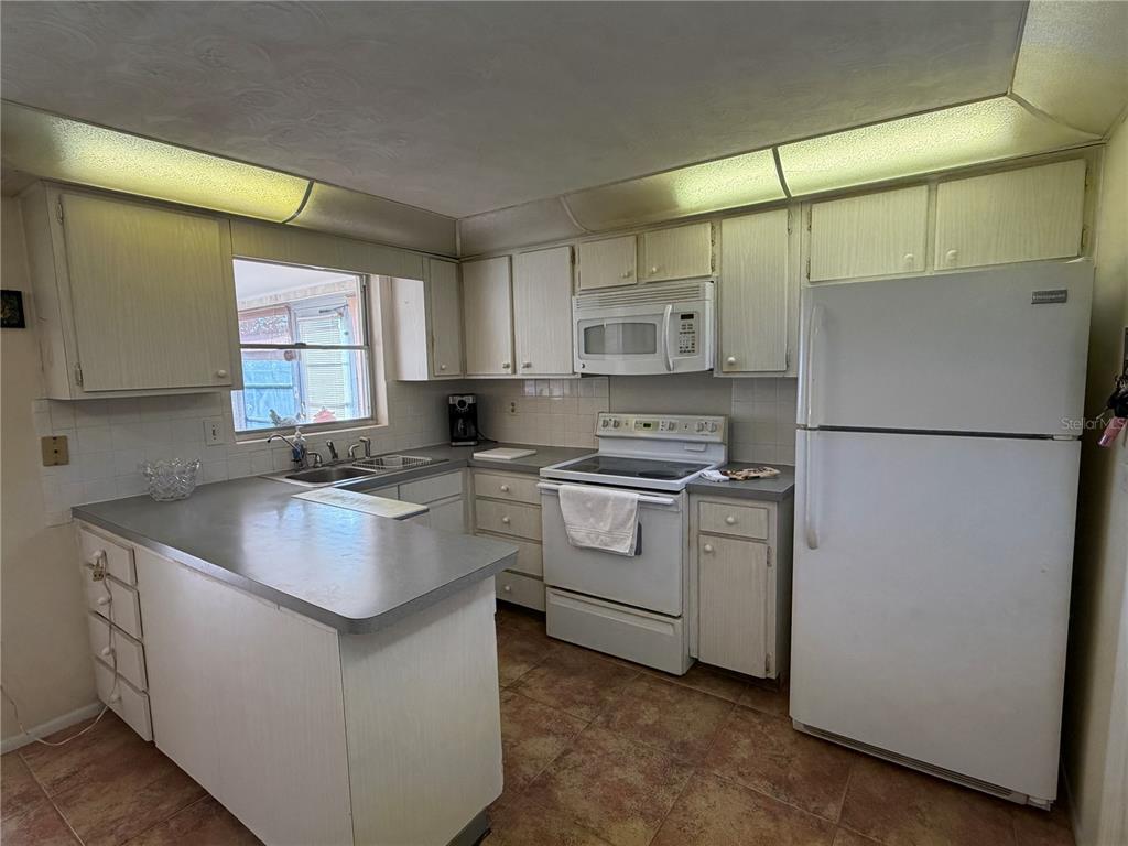 3914 Carioca Road Holiday, FL 34691 - Photo 10 of 23 a kitchen with white cabinets and white appliances