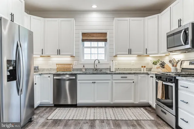 a kitchen with stainless steel appliances granite countertop a refrigerator stove and sink