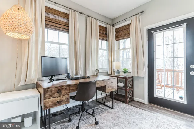 a view of a workspace with furniture and a window