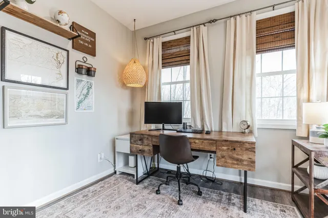 a view of a workspace with furniture and a window