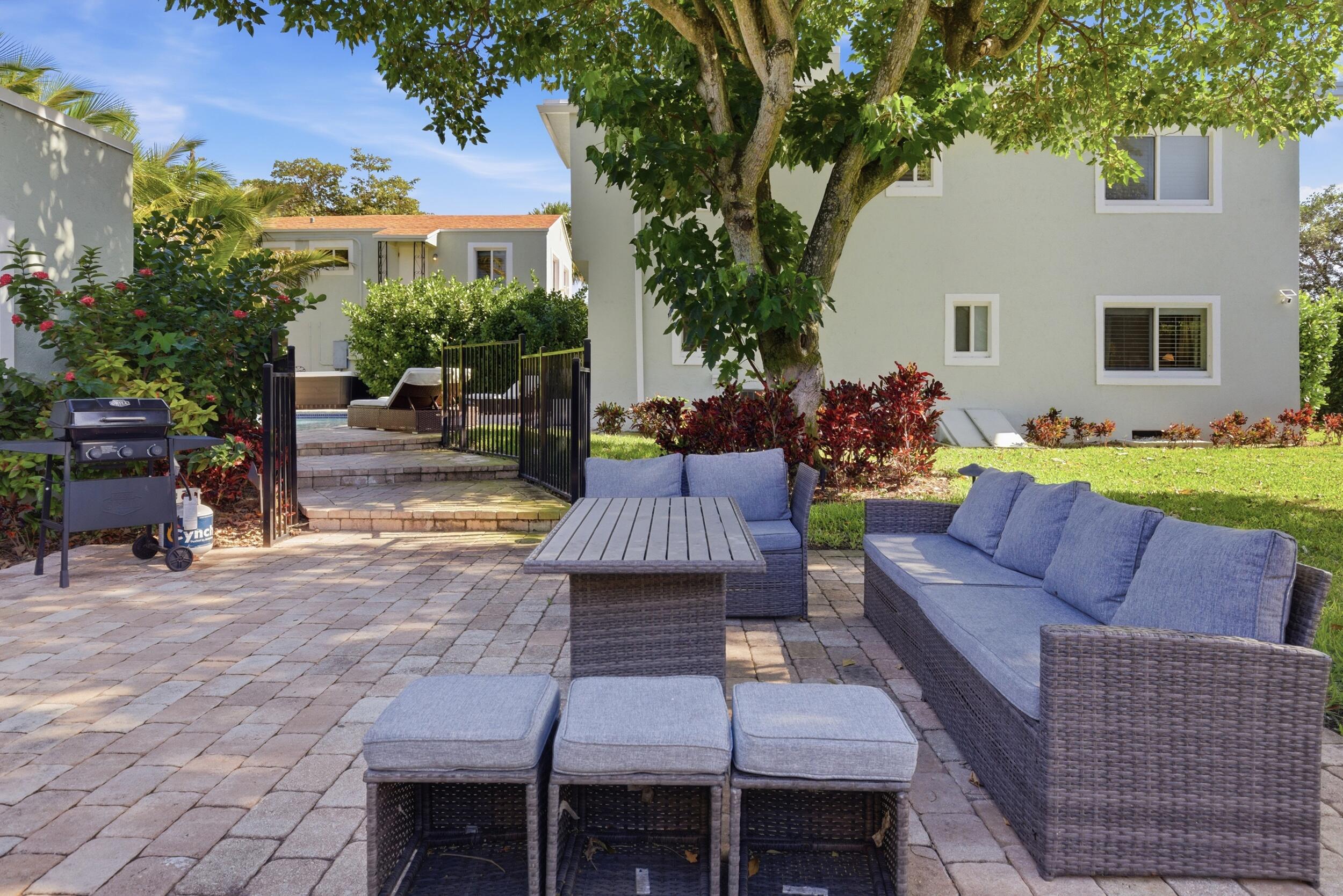 921 Ortega Road West Palm Beach, FL 33405 - Photo 51 of 60 a view of a backyard with couches potted plants and a large tree
