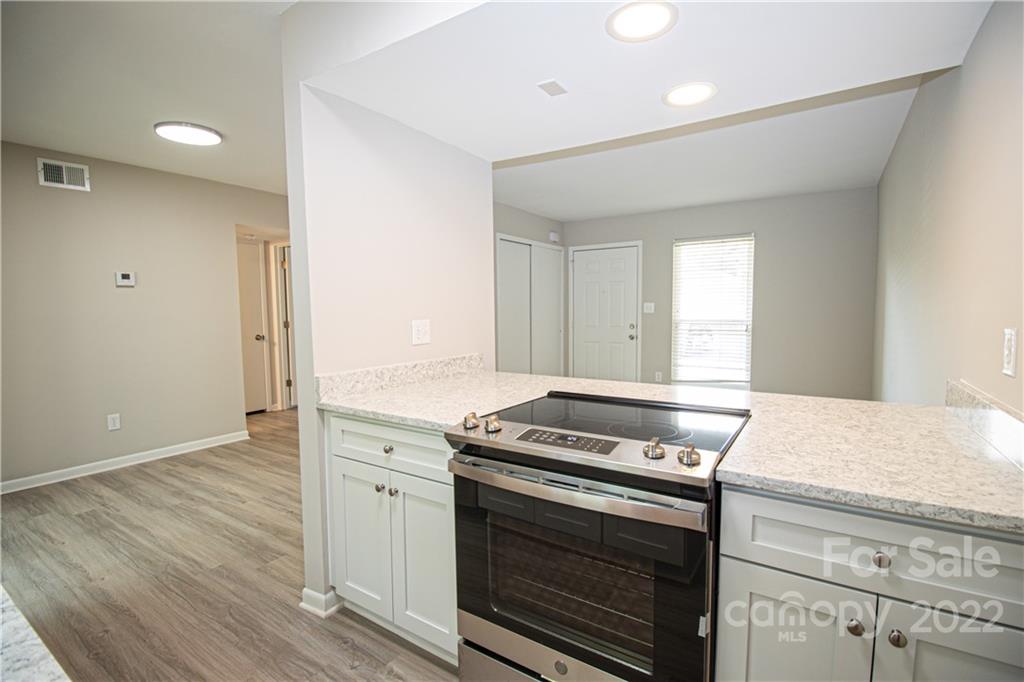 11031 Cedar View Road Charlotte, NC 28226 - Photo 8 of 25 a kitchen with a stove and white cabinets
