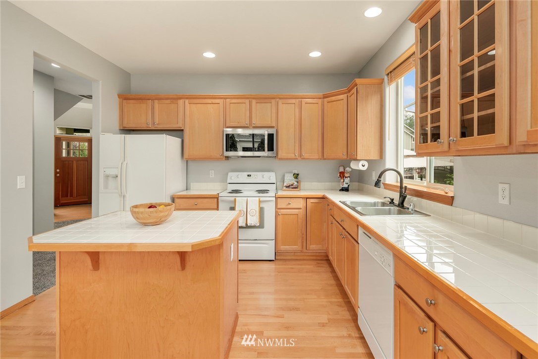 6128 Southeast 3rd Place Renton, WA 98059 - Photo 8 of 28 a kitchen with stainless steel appliances granite countertop a sink stove and a refrigerator
