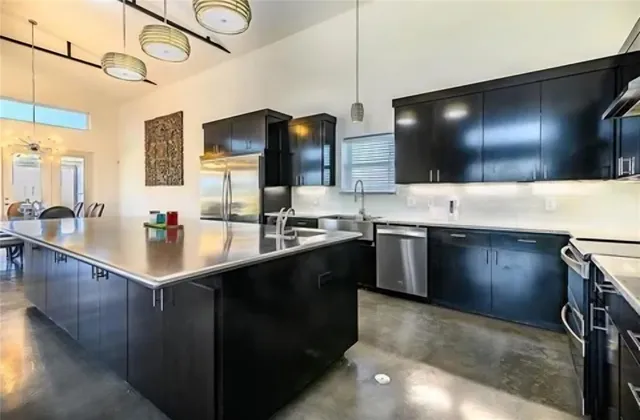 a kitchen with stainless steel appliances a sink stove and cabinets