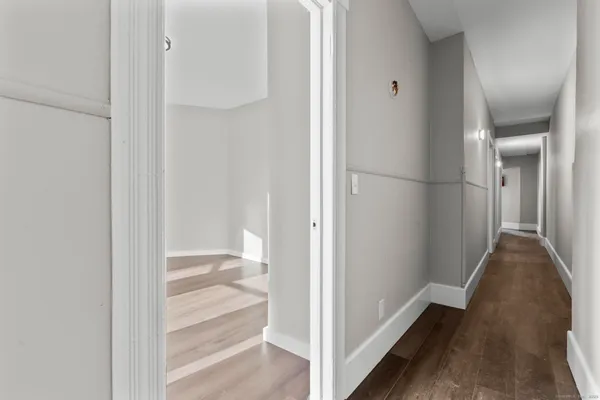 a view of a hallway with wooden floor and staircase