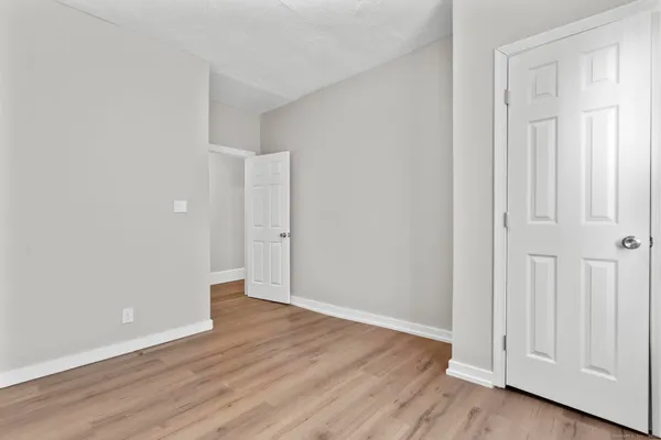 a view of an empty room with wooden floor