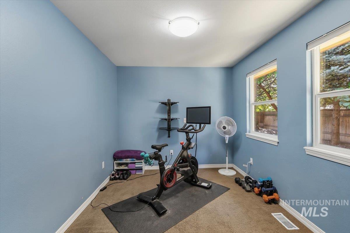 8001 West Innsbrook Court Boise, ID 83704 - Photo 20 of 39 Carpeted room with blue painted walls, featuring two windows with white trim, a flush-mount ceiling light fixture, and white baseboards