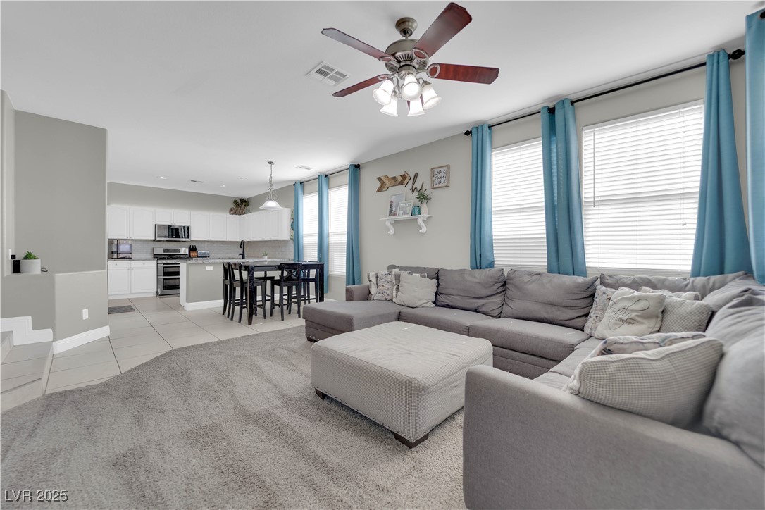 9005 Rendon Street Las Vegas, NV 89143 - Photo 16 of 51 Living area featuring light tile patterned floors, ceiling fan, and light colored carpet