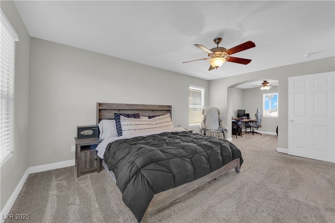 9005 Rendon Street Las Vegas, NV 89143 - Photo 19 of 51 Bedroom with light carpet, a ceiling fan, and a desk