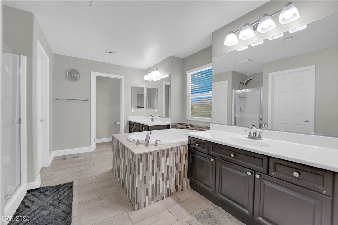 9005 Rendon Street Las Vegas, NV 89143 - Photo 23 of 51 Bathroom with a shower stall, a bath, two vanities, and wood finish floors