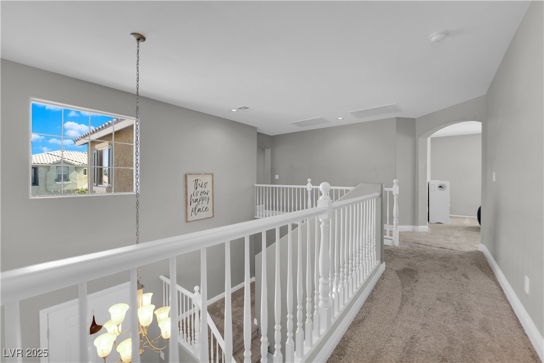 9005 Rendon Street Las Vegas, NV 89143 - Photo 29 of 51 Corridor featuring carpet, arched walkways, and an upstairs landing