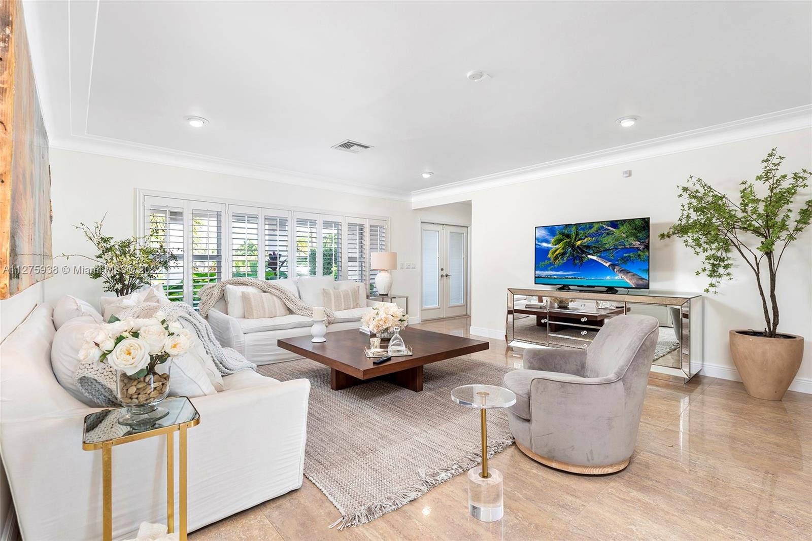 940 88th Street Surfside, FL 33154 - Photo 11 of 38 a living room with furniture a flat screen tv and a floor to ceiling window