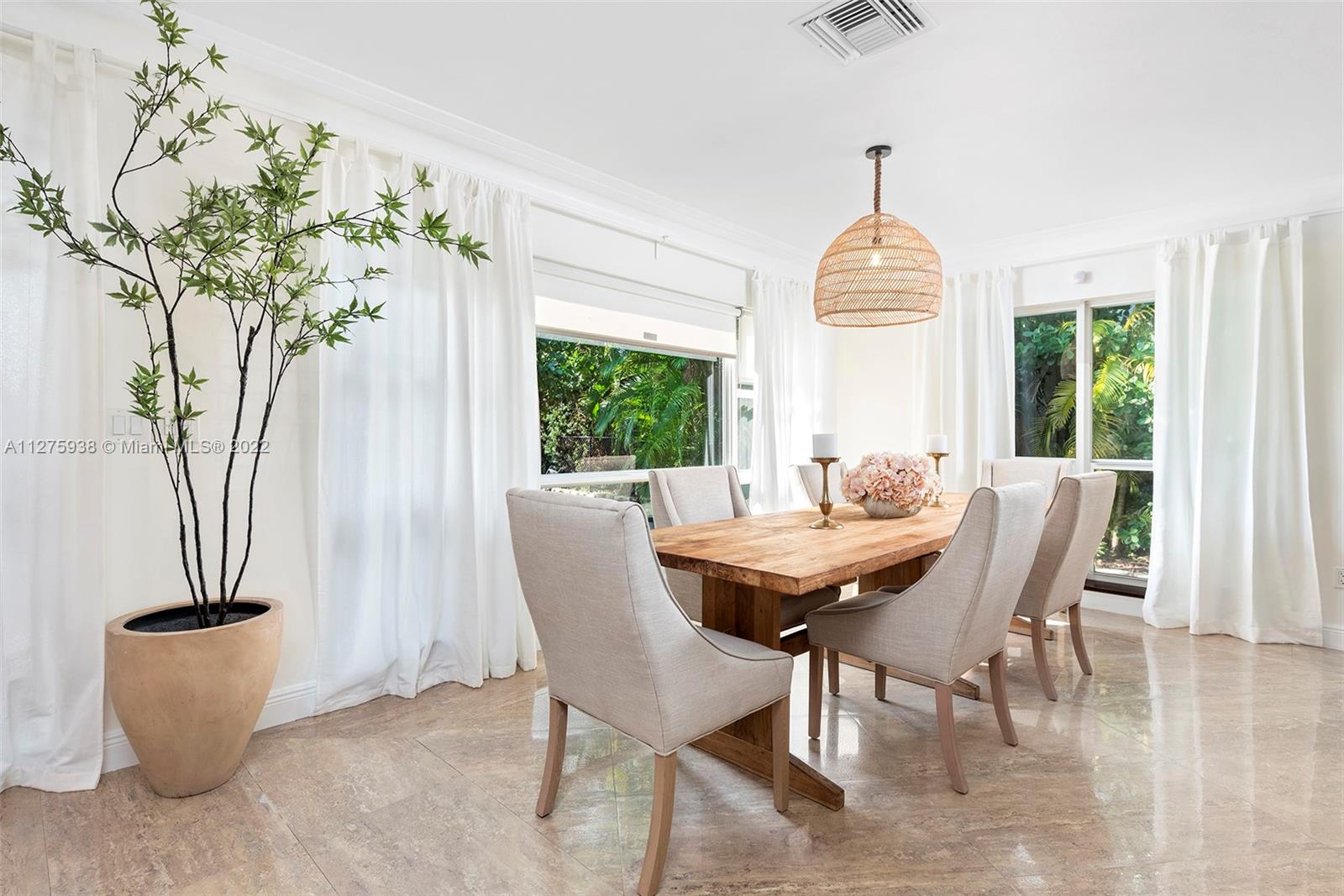 940 88th Street Surfside, FL 33154 - Photo 14 of 38 a dining room with furniture a chandelier and wooden floor