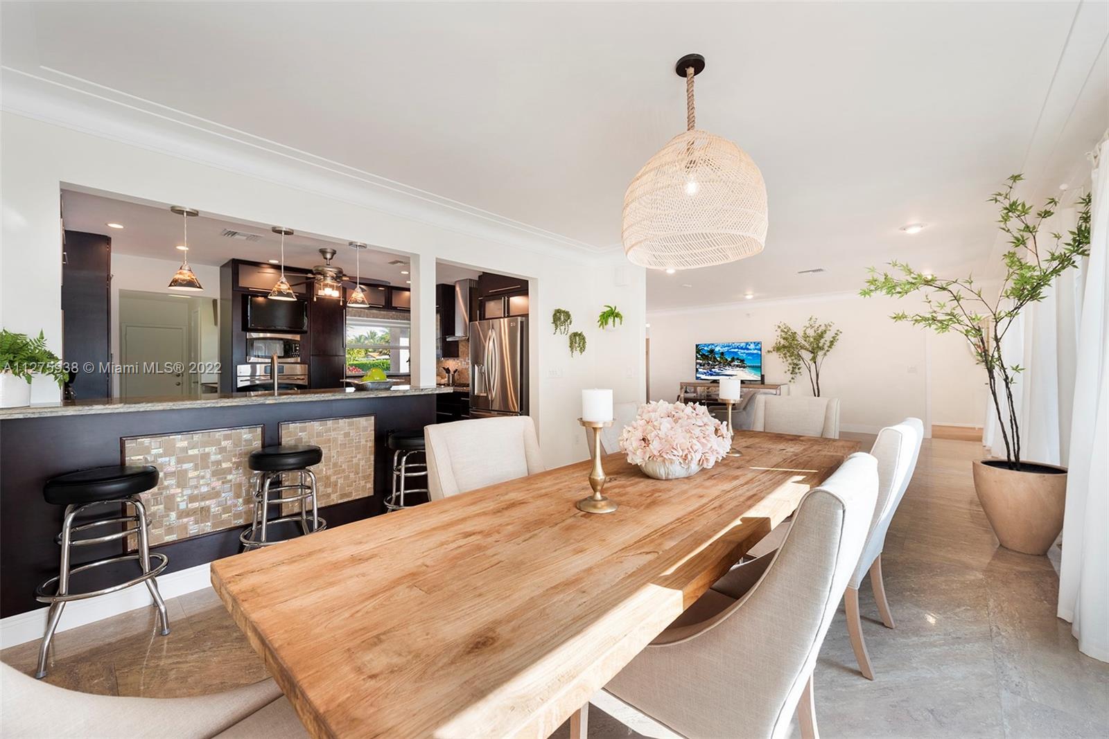 940 88th Street Surfside, FL 33154 - Photo 17 of 38 a dining room with wooden floor a chandelier a wooden table and chairs